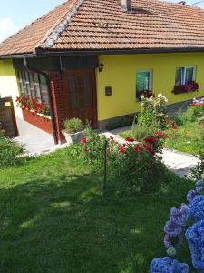 a yellow house with flowers in front of it at Subaša in Visoko