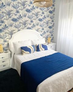 a bedroom with a bed with blue and white wallpaper at Apartamento San Roque in Betanzos