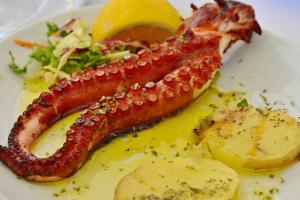 um prato de comida com uma lagosta e um limão em Elbamar Procchio em Procchio