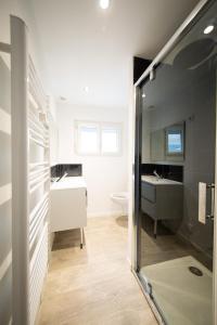 ein Badezimmer mit einem Waschbecken, einem WC und einem Spiegel in der Unterkunft NG SuiteHome - Lille I Roubaix Barbieux I Croix - Balnéo - Relax area - Netflix - Wifi - Kitchenette in Roubaix