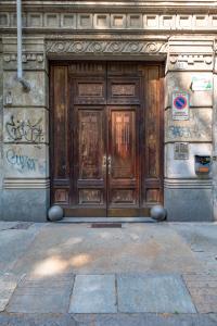 a large wooden door on the side of a building at Near Campus& Center: Teeny Tiny in Turin