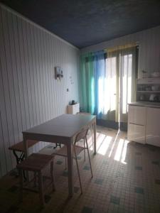 eine Küche mit einem Tisch und Stühlen im Zimmer in der Unterkunft Le petit paradis iodé in Gujan-Mestras