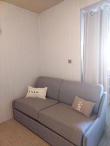 ein Sofa im Wohnzimmer mit zwei Kissen darauf in der Unterkunft Le petit paradis iodé in Gujan-Mestras