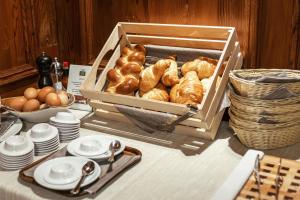 uma caixa de croissants e outros produtos de pastelaria numa mesa em Altavilla, Rooms & Breakfast em Poschiavo