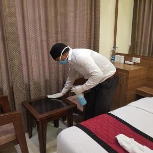 osoba stojąca w pokoju hotelowym ze stołem w obiekcie Swaran hotel w mieście Amritsar