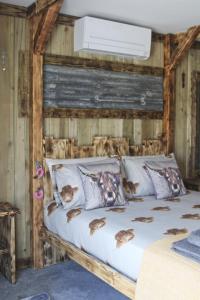 a bedroom with a bed with a wooden wall at The Moo-tel at Bargoed Farm in Aberaeron
