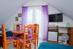 Pokój ze stołem i krzesłami oraz telewizorem w obiekcie Pokoje Gościnne IDALIA w Karwii