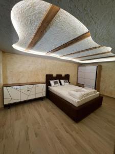 a bedroom with a large bed and a ceiling at Motel pizzeria Actros in Nova Topola