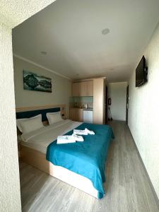 ein Schlafzimmer mit einem großen Bett mit einer blauen Decke in der Unterkunft Apart-Hotel Poseidon in Odessa