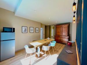 a kitchen with a table and chairs and a refrigerator at Le Five Tellier - Monkey in Reims