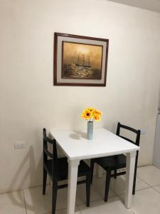 a white table and chairs with a vase of flowers on it at Hospedaje Maluli suit 4 in Santa Elena