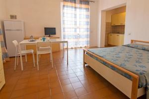 1 dormitorio con 1 cama, mesa y sillas en Elbamar Procchio, en Procchio