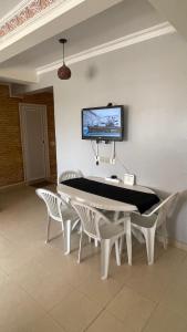 uma mesa de jantar com cadeiras e uma televisão na parede em Appartement Résidence Yassmina em Tânger
