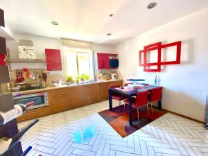 een keuken met rode kasten en een tafel met rode stoelen bij Seeview rooftop house between Sorrento and Amalfi in Massa Lubrense