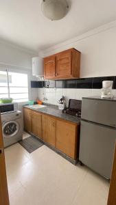 uma cozinha com armários de madeira e um frigorífico de aço inoxidável em Appartement Résidence Yassmina em Tânger