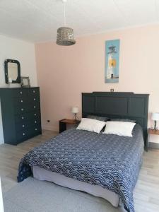 ein Schlafzimmer mit einem großen Bett und einer Kommode in der Unterkunft Gite à 5mn des plages et à 5mn de Granville in Longueville