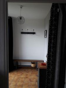 ein Raum mit einer weißen Wand und einem Tisch in der Unterkunft Gite à 5mn des plages et à 5mn de Granville in Longueville