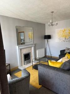 a living room with two couches and a fireplace at Workers & Visitors- Gainford 4Bedrooms in Walsgrave on Sowe