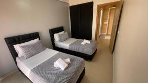 two beds in a small room with at Appartement R&eacute;sidence Yassmina in Tangier