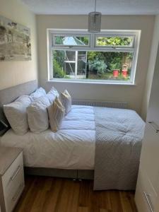 - une chambre avec un lit doté d'oreillers et d'une fenêtre dans l'établissement Workers & Visitors- Gainford 4Bedrooms, à Walsgrave on Sowe