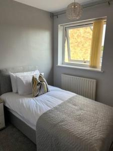 a bedroom with a white bed with a window at Workers & Visitors- Gainford 4Bedrooms in Walsgrave on Sowe