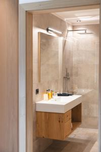 uma casa de banho com um lavatório branco e um espelho. em Hotel Lahnerhof em Vipiteno