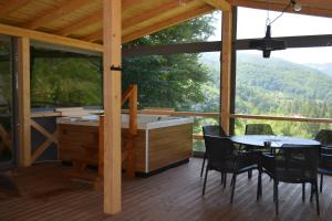 a large screened in porch with a table and a tub at Три сосни in Kosiv