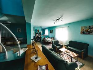 a living room with blue walls and green furniture at Villa Draga in Mostar