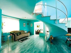 a living room with blue walls and a spiral staircase at Villa Draga in Mostar