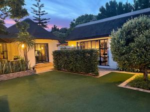 una casa con un césped verde delante de ella en Garden Retreat Guest House, en Ciudad del Cabo