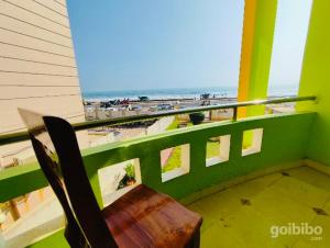 a bench on a balcony with a view of the beach at Hotel Golden Dust ! Puri - ViDi Group of Hotels in Puri