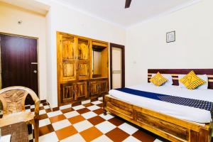 a bedroom with a bed and a checkered floor at Hotel Golden Dust ! Puri - ViDi Group of Hotels in Puri