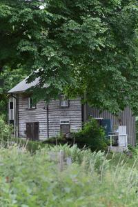 an old house sitting in the middle of a field at Henneviken BnB in Ed