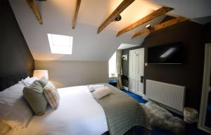a bedroom with a large white bed with a skylight at Rockview in Portree