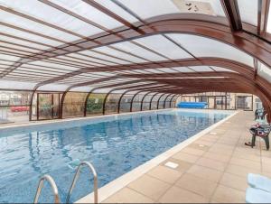 einen großen Pool mit einer einziehbaren Decke in der Unterkunft Villa sea view 3-bed heated pool eat bar kids park in Lowestoft