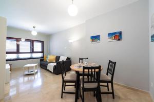 a living room with a table and chairs and a couch at Modern Apartment Canteras Beach in Las Palmas de Gran Canaria