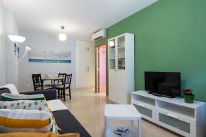 a living room with a couch and a tv at Modern Apartment Canteras Beach in Las Palmas de Gran Canaria