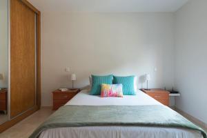 a bedroom with a large bed with blue pillows at Modern Apartment Canteras Beach in Las Palmas de Gran Canaria