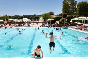 a group of people swimming in a swimming pool at Fabulous village in Casal Palocco