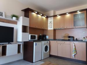 a kitchen with a washing machine and a microwave at Апартамент в комплекс Зора 9A in Sozopol