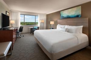 リッチモンドにあるDelta Hotels by Marriott Richmond Downtownの白い大型ベッド1台、デスクが備わる客室です。