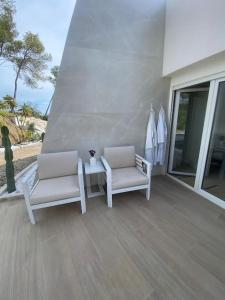 two chairs and a table on a balcony with surfboards at Villa design vue panoramique in Grabels