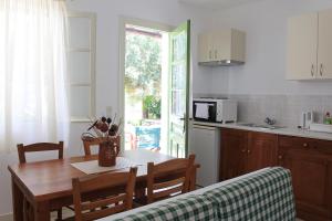 a kitchen with a wooden table and a dining room at Eleonas Apartments in Sifnos