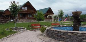 um chalé de madeira com uma piscina e bancos e uma casa em Tourist complex Karina em Polyana