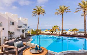 uma imagem de uma piscina num resort com palmeiras em Sea Life Nahariya BY Jacob Hotels em Nahariya