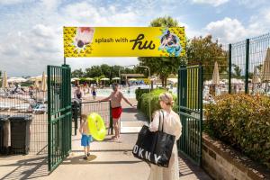 a woman and a child standing in front of a gate at Fabulous village in Casal Palocco