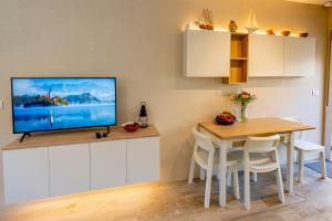 una cucina con tavolo e televisore appeso a un muro di casaplayasanxenxo a Sanxenxo
