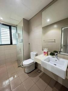 ein Badezimmer mit einem Waschbecken, einem WC und einem Spiegel in der Unterkunft Shah Alam @ Hyde Tower I-City in Shah Alam
