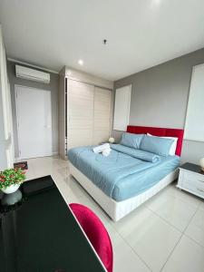 Schlafzimmer mit einem blauen Bett und einem roten Kopfteil in der Unterkunft Shah Alam @ Hyde Tower I-City in Shah Alam