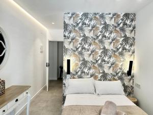 a bedroom with a large bed with a tropical wallpaper at Loft 18 Beachfront Marbella Center in Marbella